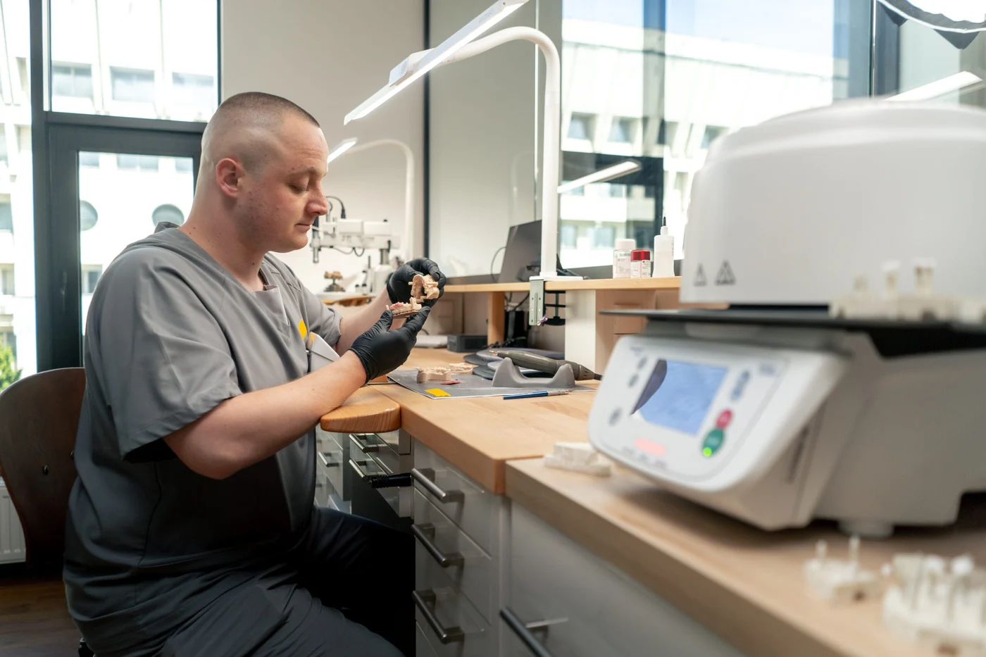 A technician carefully preparing dental restorations